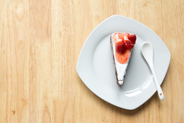 Strawberry cake with white plate on wooden background