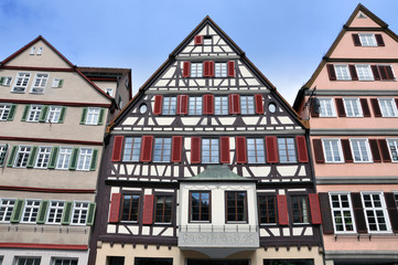 Front view of three old typical half-timbered houses with shutters. Tubingen, Baden-Wurttemberg, Germany.