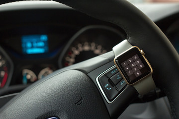 Modern car interior with smart watch on steering wheel