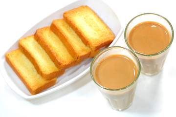 Fototapeta na wymiar Indian tea served in traditional glass cups and rusk.