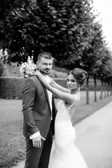 Fototapeta na wymiar wedding couple, beautiful young bride and groom standing in a park 