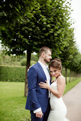 Naklejka premium wedding couple, beautiful young bride and groom standing in a park 