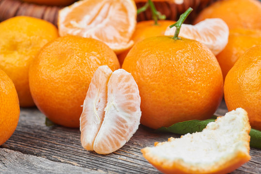 Fresh tangerines with leaves on a wooden table
