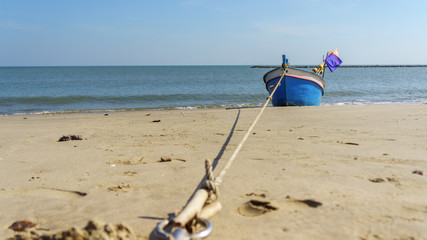 Fototapeta na wymiar fishing boat on the beach with blue sky background in Thailand