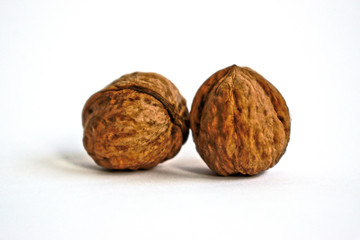 Two walnuts on a white background