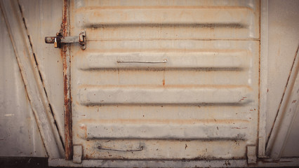 Abstract grungy metal surface and lock on rusty iron door of dining car train. Vintage train concept.