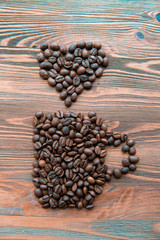 Coffee cup made from beans, grain with heart on wooden background. Valentine's Day or Wedding, love, black, frame. shaped . in shape of