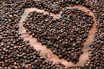 Heart shape created with coffee beans on a wooden background
