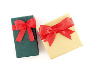 two gift boxes with red ribbon bow isolated on white background, rectangle and square cardboard boxes wrapped in green and yellow gold with simple tied bow for put presents, flat lay close up top view