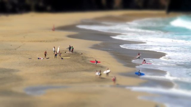 A tilt shift time lapse with surfers leaving a nudist beach. No recognizable people, nudity, trademarks or logos! 11132
