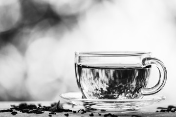 Black and white photo. Cup of  black tea on the blurred backgrou