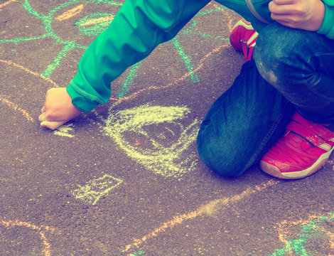 Little girl with drawings on the street