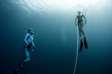 Fototapeta na wymiar Free diver ascending along the rope in the depth