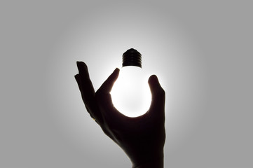 hand holding a light bulb lit