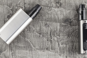 Modern electronic cigarette on a concrete background.
