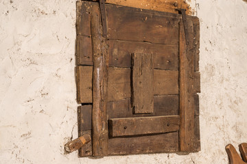 Old wooden window locked of an old house with signs of woodworm in a warehouse vintage