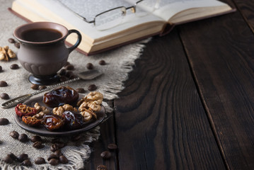Cup of coffee and book on wooden table