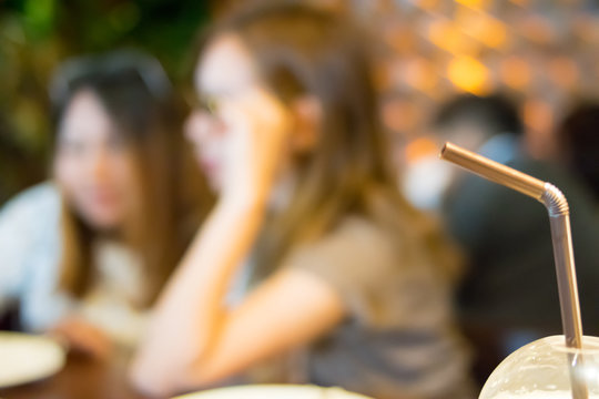 close up Straw with blurred lady on coffee shop