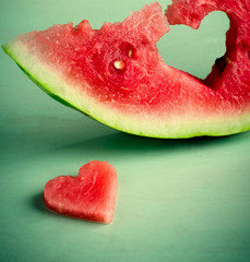 Fresh juicy watermelon heart at turquoise wooden background. Saint Valentine, love greeting card