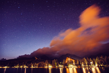 Starry sky over the lake in National Park High Tatras. Dramatic