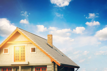 log lodge with gray tile roof against blue sky © ronstik