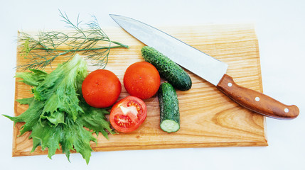 Wooden board with vegetables and knife