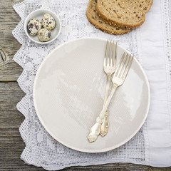 Kitchen Still Life. Serving for dinner with a gray ceramic dish on tablecloth vintadnoy handmade  silver cutlery. Top view