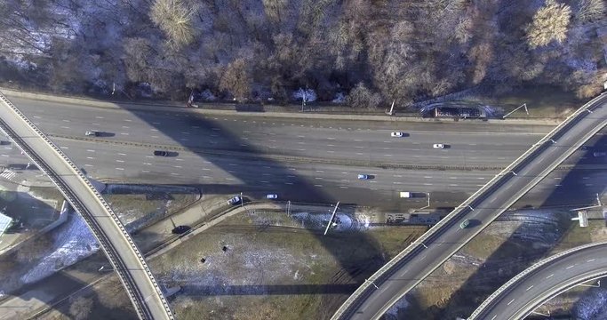 Aerial shot of a little heavy urban traffic on the highway near the forest. Public transport is moving easily.