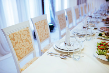 Formal stylish setting on a dinner table with elegant glassware