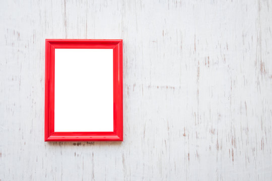Red photo frame over white rustic wooden background