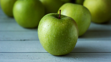 green apples on white wooden background. Selective focuse
