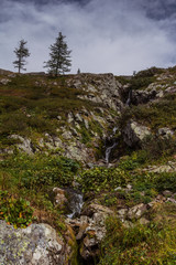 Mountain alpine landscape with waterfall and clouds in Altai, Russia
