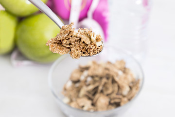 bowl of cereal with fruit, weights and tape measure and concept of diet and healthy living