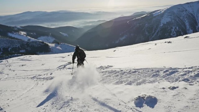 Slowmotion footage of a skier riding down the mountain.