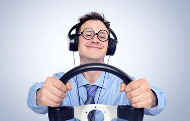 Happy funny man with glasses and headphones while driving car