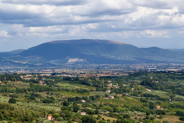 Fototapeta na wymiar Perugia, Italy. A scenic view of the surrounding area. In the center of the frame, on the hillside - Assisi