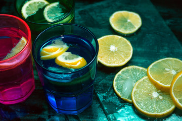 Sparkling water, soda or a gin and tonic in colorful glasses with lemon and ice.Concept for bar menu or detox  with water with lemon.