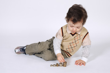 cute little boy plays with coins