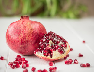 Ripe pomegranate seeds on a white wooden table. Fruit diet. Healthy lifestyle.