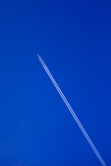 Airplane with chemtrails on blue sky
