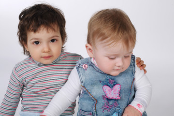 two cute hugging children on white