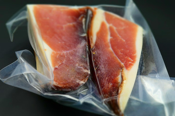 A big piece of Italian speck in vacuum packing. Tilt-shift effect applied.