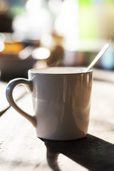 Hot coffee in a white cup on a wooden table.