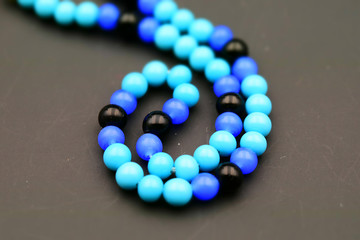 Turquoise and blue beads on black background. Tilt-shift effect applied.