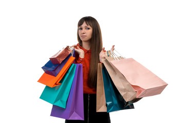 Young long-haired woman holds shopping purchases, many colorful