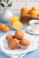 Fresh pastries, tea and orange juice on a light background closeup