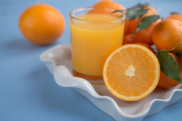 Fresh orange juice in a glass on a background of fruit baskets