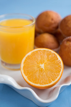 Fresh pastries and orange juice on a light background closeup