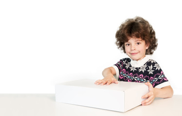 Surprised cute boy put his hand on the white box, smiling and looking at the camera. White background.