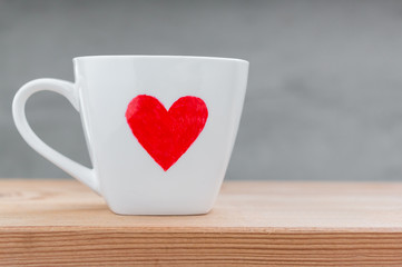 Cup of love  on wood table over grunge cement background
